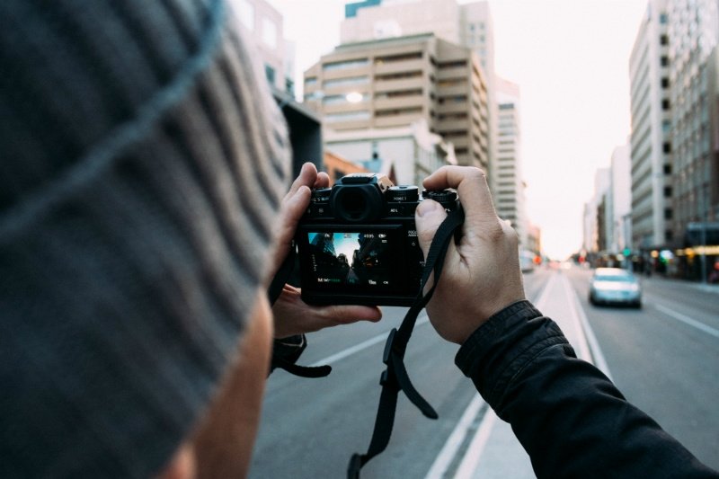 homme qui prend une photo avec un appareil numérique